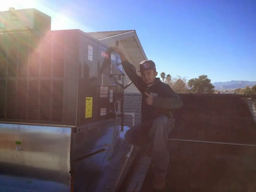 HVAC technician performing Boiler Repair on a rooftop unit in Decatur